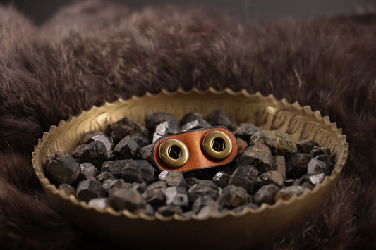 Back of cognac leather cat charm with smooth finish and snap closures.