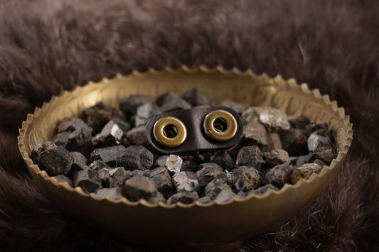 Back of red ostrich leather charm with snap closures on black leather.