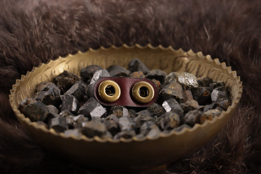 Back of oxblood leather cat charm with clean finish and snap closures.