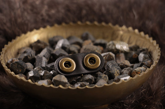 Back of black leather cat ID charm with snap fasteners and smooth backing.