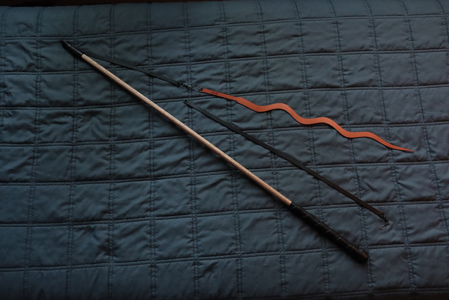 Full view of Deluxe prey wand with leather-wrapped handle, two leather strings, and cognac Prey-lude attachment toy.