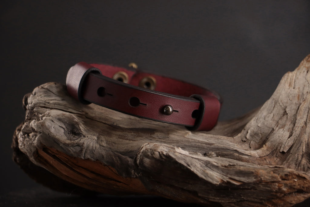 Back of oxblood leather cat collar showing adjustable snap sizing system.