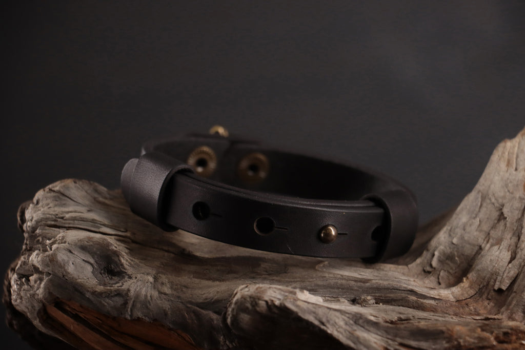Back of black leather cat collar showing adjustable snap sizing system.