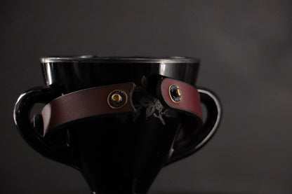 Oxblood cat collar unsnapped to show breakaway closure.