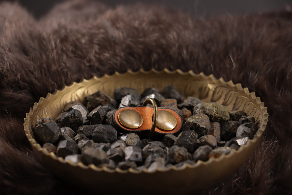 Front of cognac leather cat ID tag charm with antique bronze D-ring.
